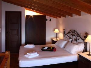 a bedroom with a large bed with a tray on it at Kekrifalia Hotel in Skala