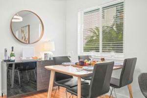 a dining room with a table and chairs and a mirror at Condo by the Beach King Bed Lush Patio w BBQ Breakers Key Three H0MES in Fort Lauderdale