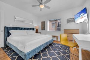 a bedroom with a bed and a desk and a tv at Condo by the Beach King Bed Lush Patio w BBQ Breakers Key Five H0MES in Fort Lauderdale