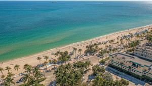 an aerial view of a beach with palm trees and the ocean at Condo by the Beach King Bed Lush Patio w BBQ Breakers Key Five H0MES in Fort Lauderdale +10 photos