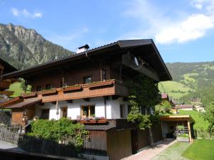 una casa en las montañas con una valla en Ferienwohnungen Unterfeld en Alpbach