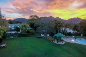 an aerial view of a yard with a pool and mountains at Le Manoir de Brendel in Franschhoek