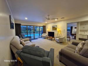 ケリケリにあるKerikeri Central Houseのソファとテレビ付きの広いリビングルーム