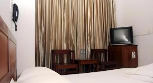 ダナンにあるOne Star Hotel Danangのベッドとテレビと椅子のある寝室