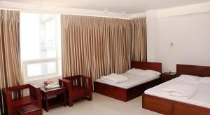 ダナンにあるOne Star Hotel Danangのベッドが2つと窓があるホテルの部屋