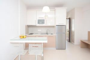 a white kitchen with a counter and a refrigerator at Georgio Seaside Hotel in Finikounta