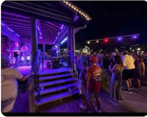 una multitud de personas de pie alrededor de un escenario por la noche en Cozy 2BR in The Villages With BBQ and 4 Seaters Golfcart King Bed, en Wildwood 38 fotos más