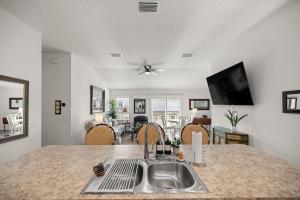 Una cocina con fregadero y una sala de estar. en Cozy 2BR in The Villages With BBQ and 4 Seaters Golfcart King Bed, en Wildwood
