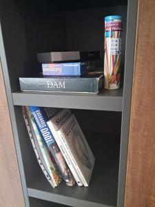 Una estantería llena de libros y una bebida. en Apartmán Akademik, en Banská Štiavnica