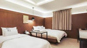 龙仁市Yongin(Giheung) M7 Hotel的有两张床和一张桌子的酒店房间