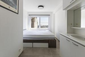 een slaapkamer met een bed en een raam bij Santa Rosa in Blankenberge
