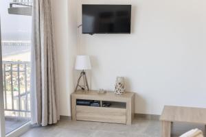 een woonkamer met een tv en een tafel met een lamp bij Santa Rosa in Blankenberge