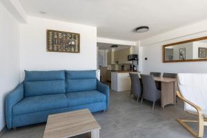 een woonkamer met een blauwe bank en een tafel bij Santa Rosa in Blankenberge