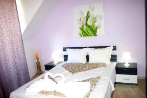 um quarto com uma cama com um vaso de flores na parede em Sea View Apartments em Sozopol
