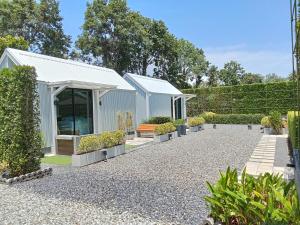 a garden with a greenhouse and some plants at Fill up mini home in Nong Prue