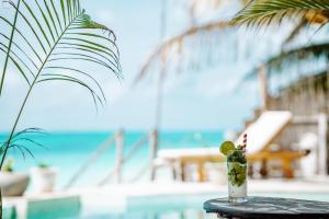 a drink on a table next to the beach at Pili Pili Tropical Island in Jambiani