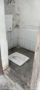 a dirty bathroom with a toilet in the floor at Sharma Homestay in Kālīnagar