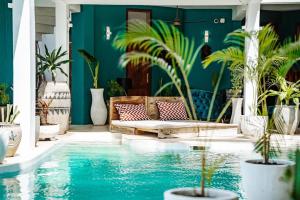 a house with a swimming pool with a couch and potted plants at Pili Pili Tropical Island in Jambiani