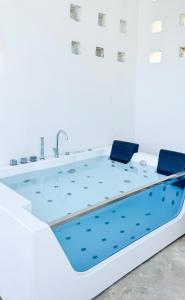 a bathtub in a white room with a blue floor at Pili Pili Tropical Island in Jambiani