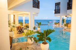 a swimming pool with plants and the ocean in the background at Pili Pili Tropical Island in Jambiani +35 photos