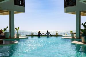 a group of three people holding hands in a swimming pool at Pili Pili Tropical Island in Jambiani