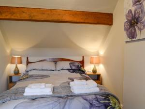 una camera da letto con un letto grande con due cuscini di Rose Cottage a Cleator Altre 7 foto