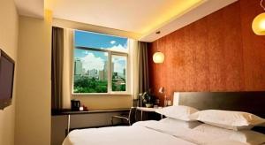 a hotel room with a bed and a window at Fairyland Hotel Kunming Tuodong Branch in Kunming +85 photos