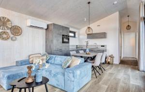 a living room with a blue couch and a kitchen at Awesome Home In Kerkdriel With Wifi in Kerkdriel