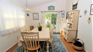una sala da pranzo con tavolo, sedie e una finestra di Cliffside Cottage a North Cape May