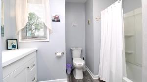 un bagno bianco con wc e doccia di Cliffside Cottage a North Cape May Altre 18 foto