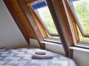 a bedroom with two towels on a bed with windows at Crown Cottage in Hartest