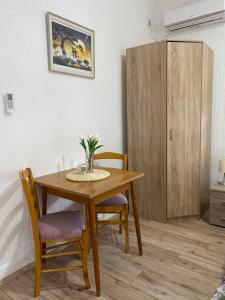 a dining room table with two chairs and a cabinet at Apartman studio Milojkovic in Golubac