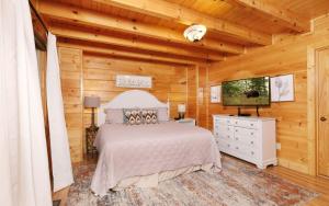 a bedroom with a bed and a flat screen tv at Rockin in the Smokies in Pigeon Forge +39 photos