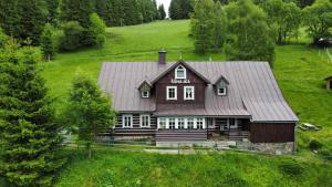 a large wooden house in a green field at Chata Šohajka - all inclusive & wellness in Pec pod Sněžkou