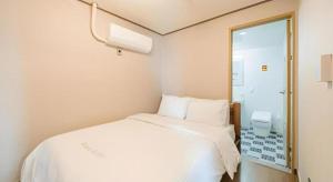 a white bed in a room with a window at Jeju Maple Hotel in Jeju +142 photos