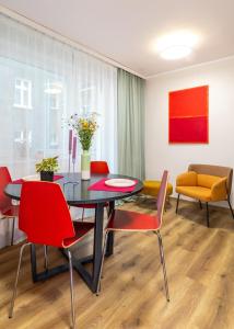 een eetkamer met een tafel en rode stoelen bij Between the Old Town and the Beach in Gdańsk