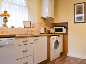 a kitchen with a washing machine and a sink at Shambles Cottage in Ambleside