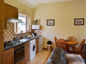 una cucina con fornello forno superiore accanto a un tavolo di Black Horse Cottage a Pentraeth
