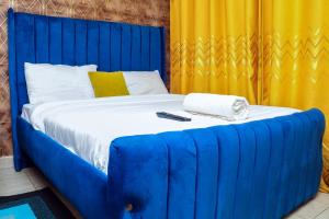 a blue bed with a remote control on top of it at Aheri Homes in Ruaka