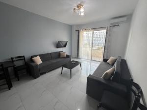 a living room with a couch and a table at Iona Apartment Golem 2 in Polisi i Vogël