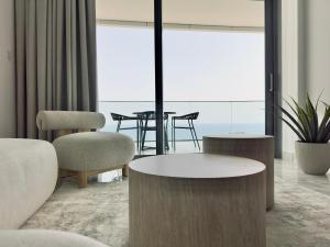 a living room with a table and chairs at Luxury 1 Bed in Trilogy, Limassol Seafront in Limassol +56 photos