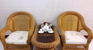 three wicker chairs with a table with a tea pot on it at Quang Sang Hotel Can Tho in Can Tho +57 photos