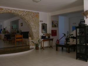 a living room with a stone archway and a table at Eri Hotel in Parikia