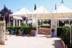 un pabellón blanco con macetas en un patio en Hotel Verona en Puertollano