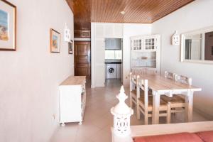 a kitchen and dining room with a table and chairs at Apartamentos Tio Papel in Albufeira