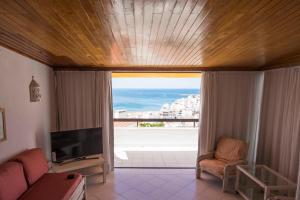 a living room with a view of the ocean at Apartamentos Tio Papel in Albufeira
