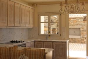 a kitchen with a sink and a stove top oven at Aqua Dream Villa in Vourkari