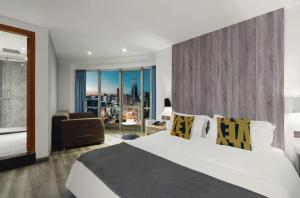 a bedroom with a large white bed and a chair at Bi'an Time Hotel -Chongqing Guanyin Bridge Branch in Chongqing