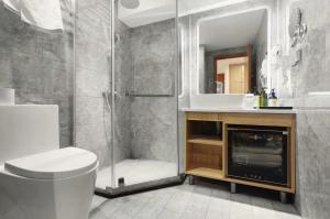 a bathroom with a shower and a toilet and a sink at Bi'an Time Hotel -Chongqing Guanyin Bridge Branch in Chongqing