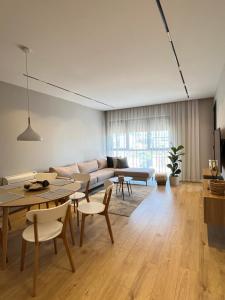 ティラナにあるBliss Apartmentのソファとテーブルと椅子のあるリビングルーム